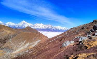 Scenic view of the Phoktey Dara Trek with snow-covered Himalayan peaks, rugged mountain terrain, and clear blue skies