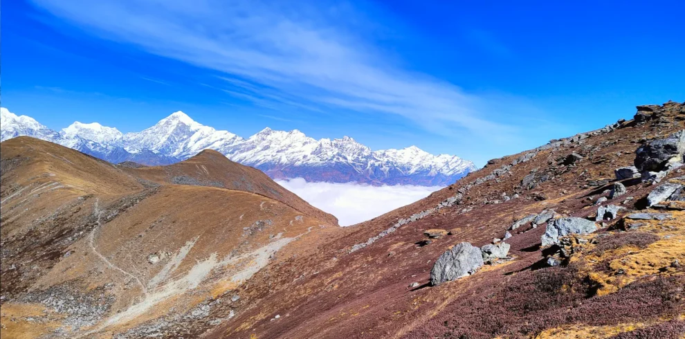 Scenic view of the Phoktey Dara Trek with snow-covered Himalayan peaks, rugged mountain terrain, and clear blue skies