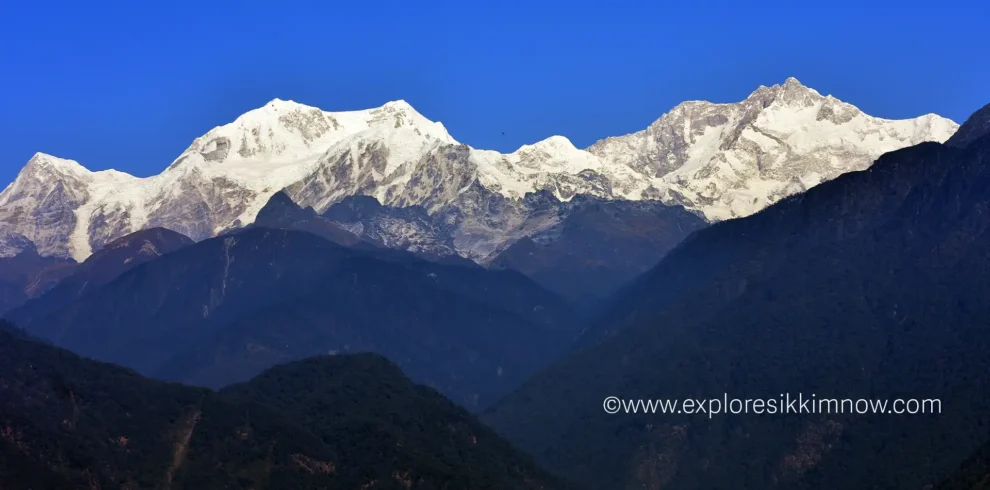 Snow-capped Kanchenjunga mountain viewed from Pelling in West Sikkim under a clear blue sky.