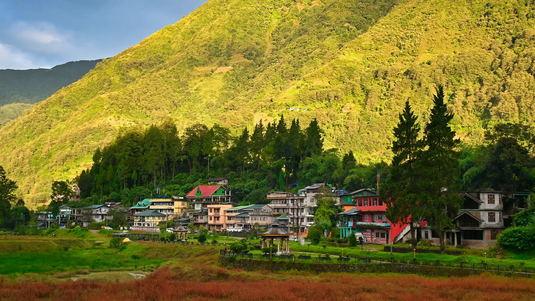 Scenic view of Uttarey town in West Sikkim with village houses set below lush mountain slopes.